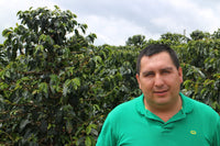ASOBOMBO Coffee Farmer in front of coffee trees Huila Colombia